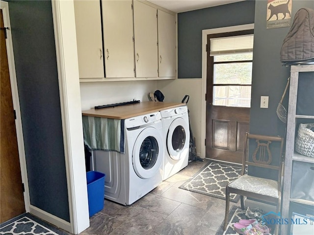 clothes washing area with washer and dryer and cabinet space