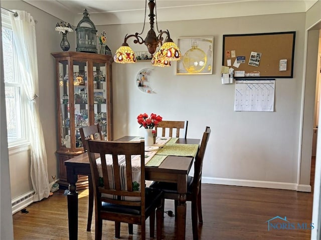 dining area with baseboards and wood finished floors