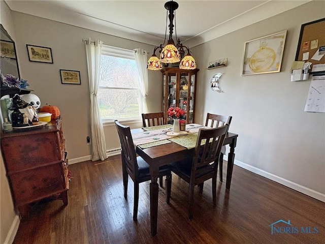 dining area featuring dark wood-style flooring, baseboards, and a baseboard radiator