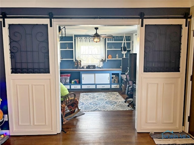 bedroom featuring wood finished floors and a barn door