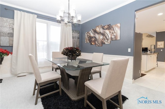 dining area with light colored carpet, a notable chandelier, and crown molding
