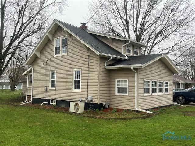 view of side of property featuring ac unit, a lawn, and a chimney