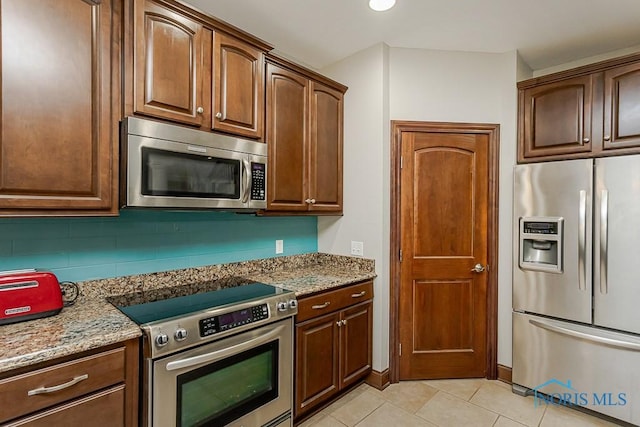 3643 Boulder Ridge Dr, Maumee, OH 43537 - kitchen with decorative backsplash, light stone countertops, stainless steel appliances, and light tile patterned floors