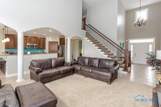 3643 Boulder Ridge Dr, Maumee, OH 43537 - living room featuring decorative columns, a high ceiling, an inviting chandelier, and light tile patterned flooring