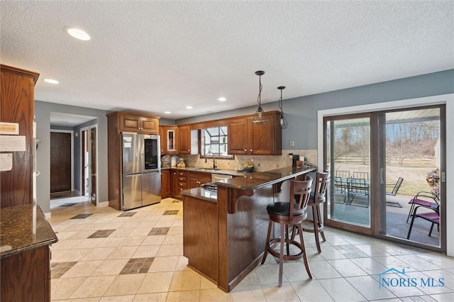 7106 Country Creek Rd, Maumee, OH 43537 - kitchen with appliances with stainless steel finishes, a sink, a peninsula, brown cabinets, and recessed lighting