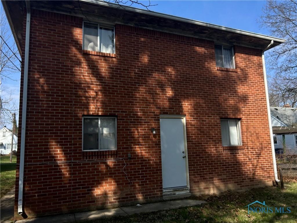 rear view of property with brick siding