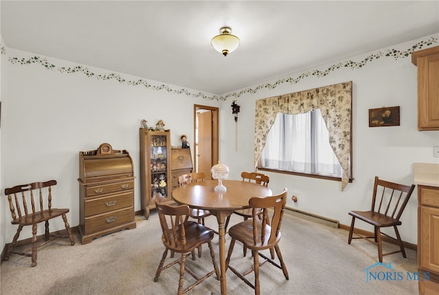dining room with light colored carpet and baseboards