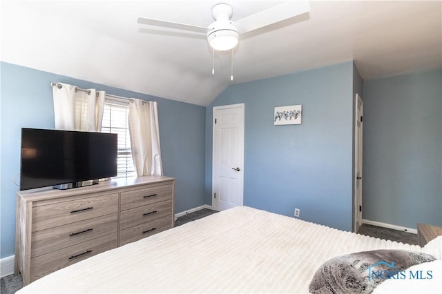 carpeted bedroom featuring baseboards, vaulted ceiling, and ceiling fan