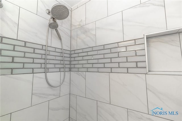interior details featuring a tile shower