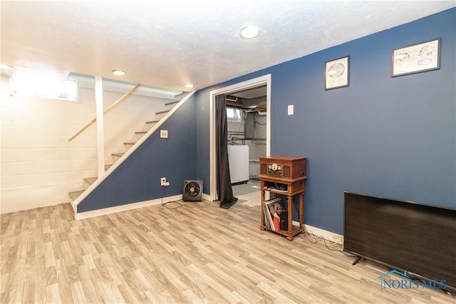 below grade area featuring washer / clothes dryer, stairway, baseboards, and wood finished floors