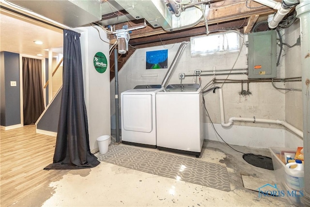 washroom with electric panel, independent washer and dryer, and laundry area