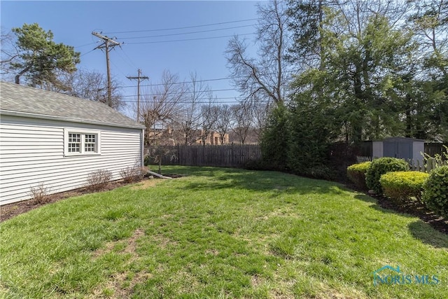 view of yard featuring an outbuilding and fence