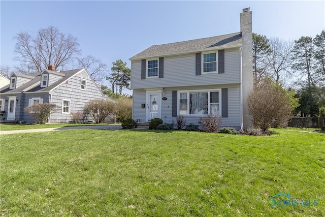 colonial house with a chimney and a front yard