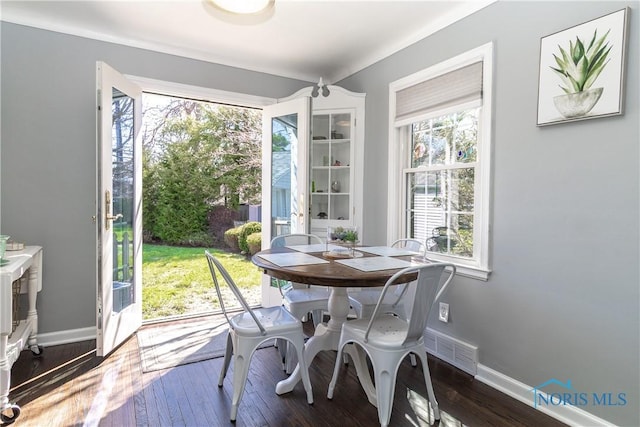dining space with visible vents, baseboards, and dark wood finished floors