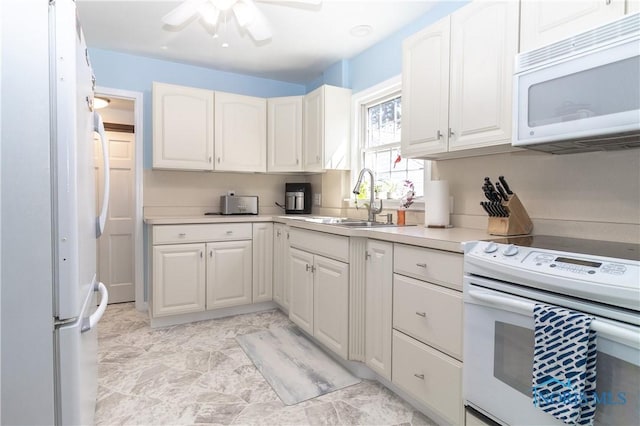 kitchen featuring a ceiling fan, white cabinetry, a sink, and white appliances