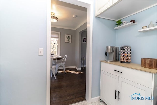 interior space with arched walkways, light wood finished floors, and baseboards