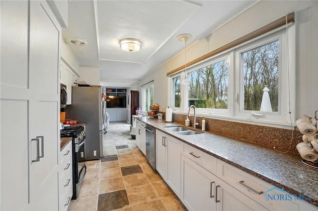 2257 N Carriage Ln, Port Clinton, OH 43452 - kitchen with dark stone countertops, a sink, white cabinetry, and stainless steel appliances