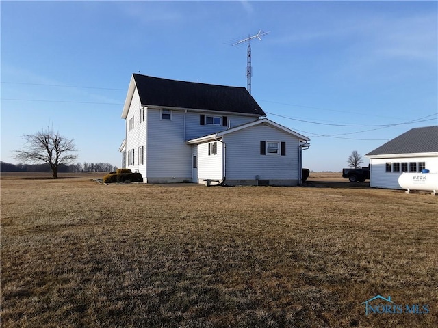 back of property with a lawn