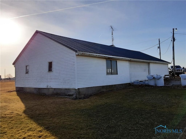 view of property exterior featuring a yard and metal roof