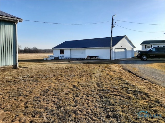 view of outdoor structure featuring an outbuilding, driveway, and a garage