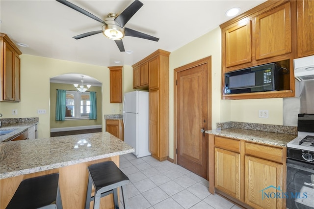 2720 106th St, Toledo, OH 43611 - kitchen featuring gas stove, black microwave, a ceiling fan, freestanding refrigerator, and light stone countertops