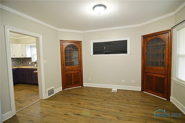 entryway featuring ornamental molding, baseboards, dark wood finished floors, and visible vents