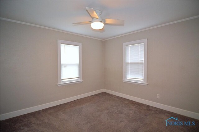 spare room featuring crown molding, baseboards, dark colored carpet, and ceiling fan