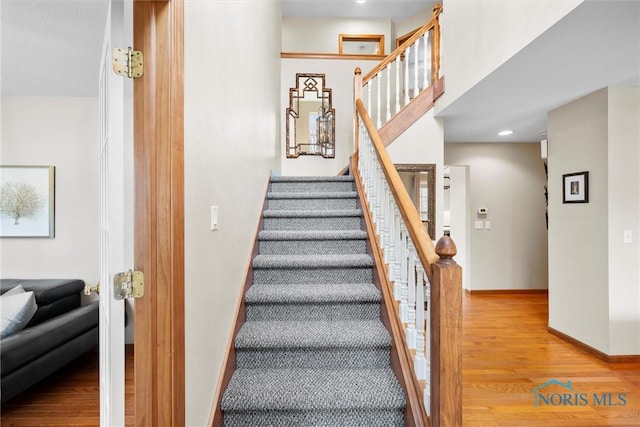 staircase with baseboards and wood finished floors