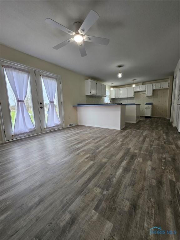 10308 Dowling Rd, Perrysburg, OH 43551 - kitchen with a peninsula, dark wood-style flooring, dark countertops, a ceiling fan, and open floor plan