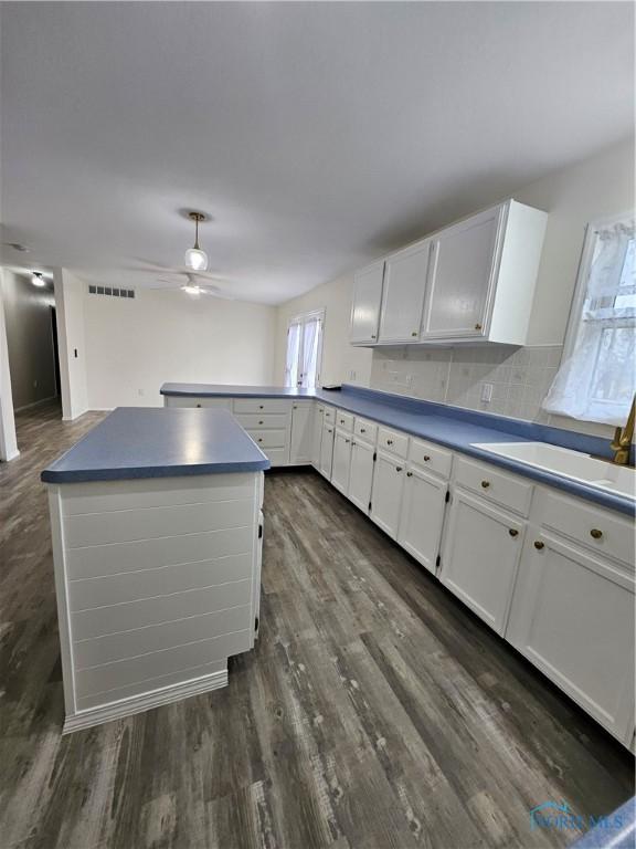 10308 Dowling Rd, Perrysburg, OH 43551 - kitchen with a ceiling fan, white cabinetry, dark wood-style flooring, a sink, and a peninsula