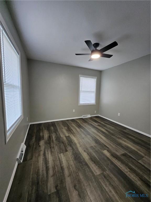 10308 Dowling Rd, Perrysburg, OH 43551 - spare room featuring dark wood-style floors, baseboards, and ceiling fan