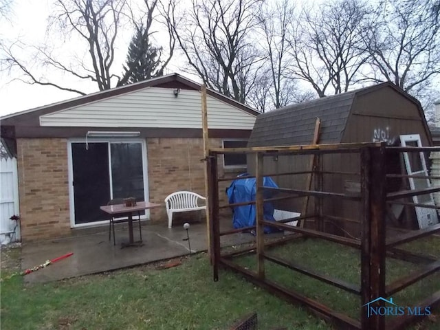 2332 Airline Ave, Toledo, OH 43609 - rear view of property featuring brick siding, a patio area, and a gambrel roof