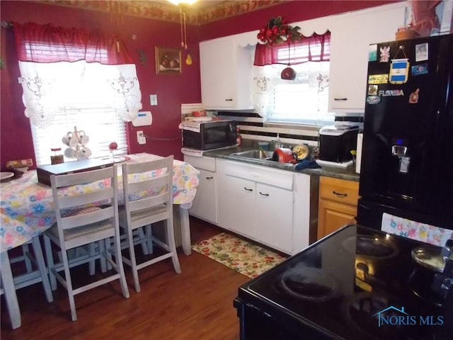 2332 Airline Ave, Toledo, OH 43609 - kitchen featuring black appliances, a sink, wood finished floors, and dark countertops