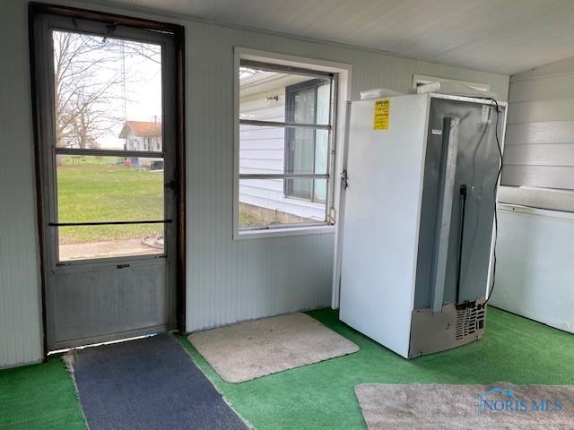 doorway to outside with plenty of natural light and carpet flooring
