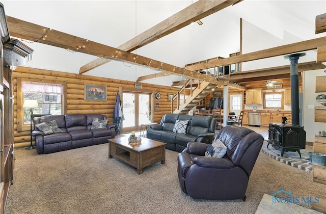 2525 N King Rd, Toledo, OH 43615 - living area featuring log walls, high vaulted ceiling, a wood stove, stairs, and carpet