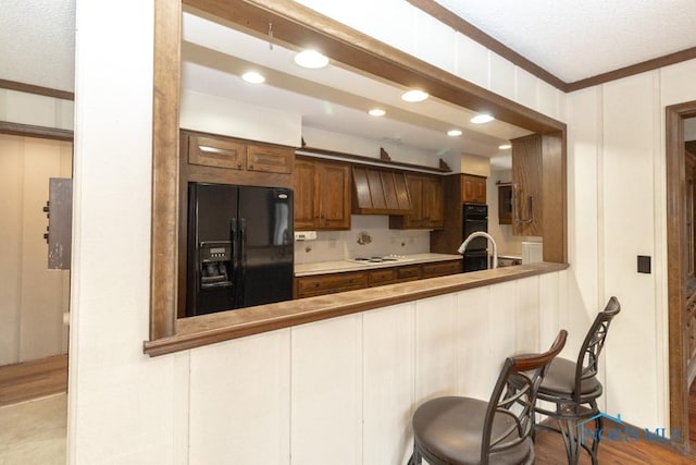 kitchen featuring custom range hood, black refrigerator with ice dispenser, recessed lighting, a peninsula, and backsplash