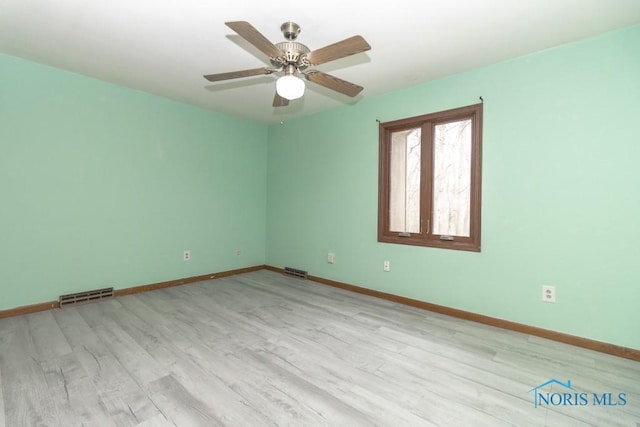 empty room with wood finished floors and visible vents
