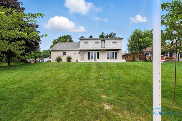 2560 Shoreland Ave, Toledo, OH 43611 - back of house with a balcony, a lawn, and brick siding