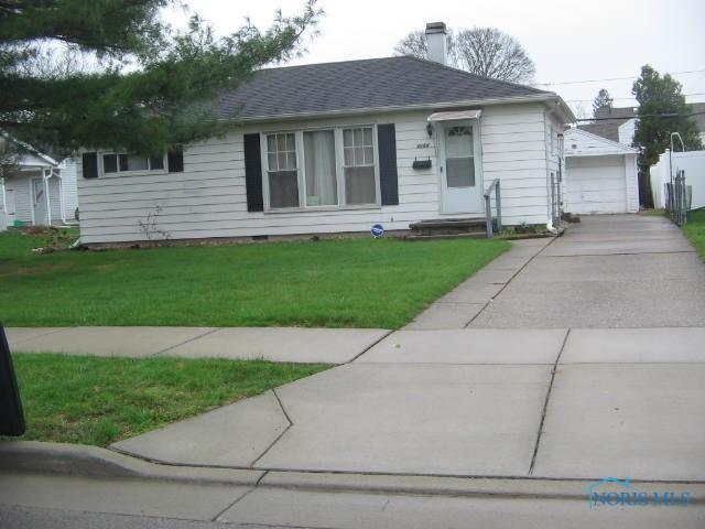 3264 Escott Ave, Toledo, OH 43614 - view of front facade featuring a front yard, a detached garage, a chimney, an outdoor structure, and roof with shingles