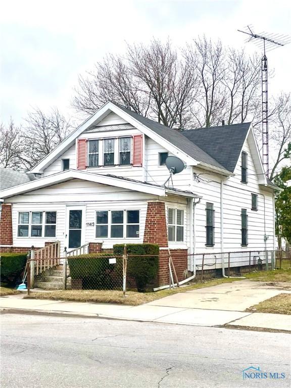 1143 S Nebraska Ave, Toledo, OH 43607 - view of front facade featuring brick siding and a fenced front yard