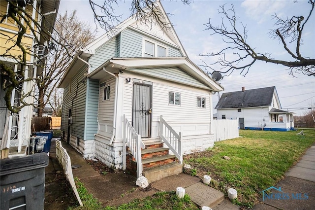 1110 Montrose Ave, Toledo, OH 43607 - view of front of house with entry steps, fence, and a front lawn