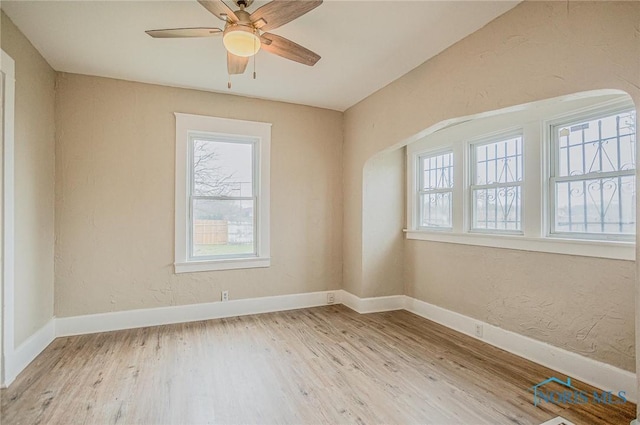 1110 Montrose Ave, Toledo, OH 43607 - spare room featuring arched walkways, baseboards, wood finished floors, and a healthy amount of sunlight