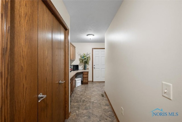 6681 Bellflower Ct, Curtice, OH 43412 - corridor featuring a desk, baseboards, and stone finish flooring
