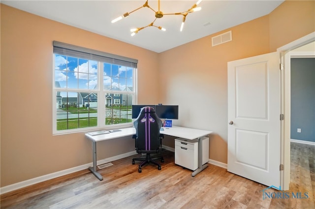 office space with visible vents, baseboards, light wood-type flooring, and an inviting chandelier