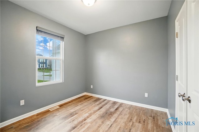 unfurnished room with visible vents, baseboards, and light wood-type flooring