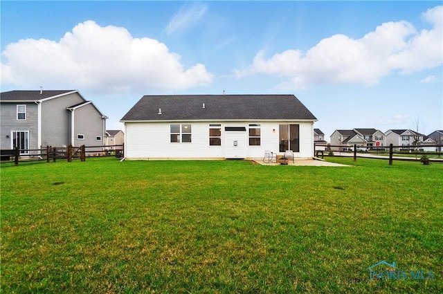 rear view of property featuring a patio, a fenced backyard, and a lawn
