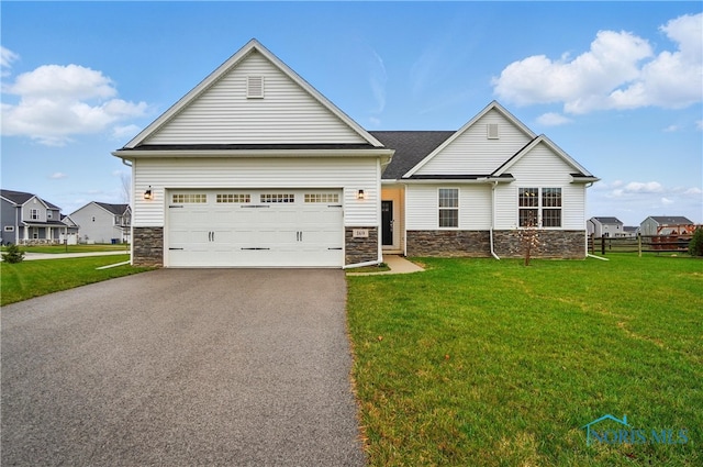 view of front of home featuring stone siding, an attached garage, a front lawn, aphalt driveway, and fence