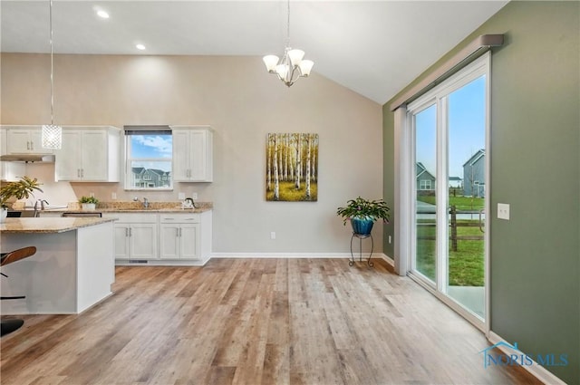 unfurnished dining area with light wood-style floors, an inviting chandelier, and plenty of natural light
