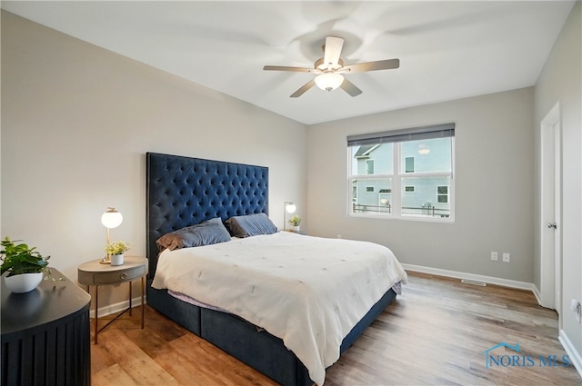 bedroom with wood finished floors, baseboards, and a ceiling fan
