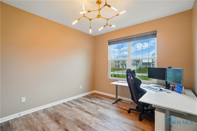 office area with baseboards, a chandelier, and wood finished floors